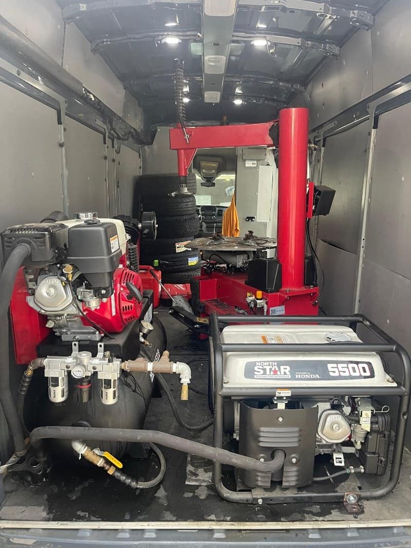 Technician performing onsite tire service on customer vehicle